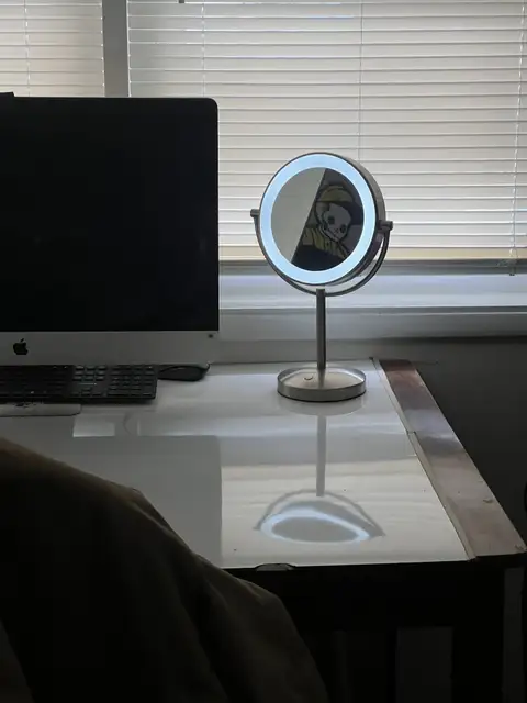 A glowing mirror reflects a screen, illuminating the workspace. - Grandview Heights, Ohio